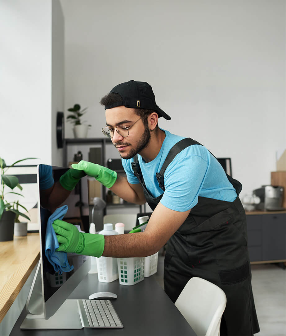 Man wiping down a computer screen